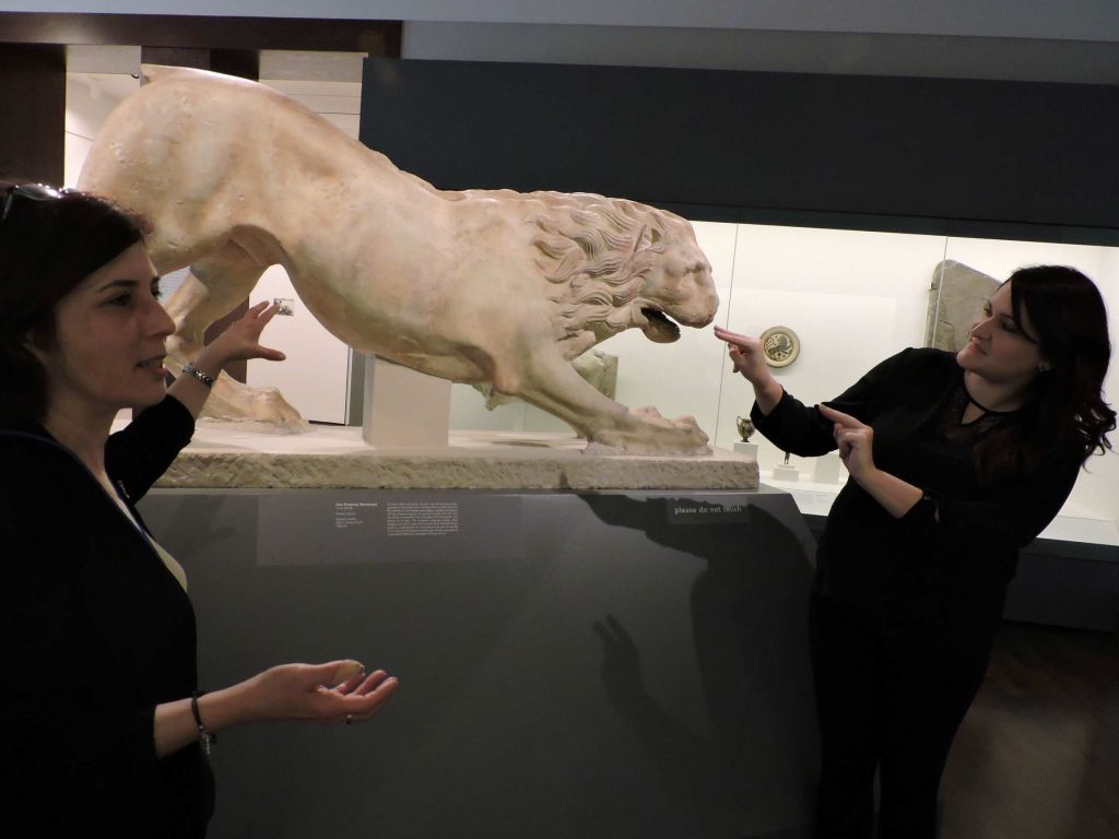 Two people next to a statue of a lion